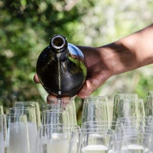 closeup-hand-pouring-last-droplet-sparking-wine-into-wine-glasses-outdoor-part